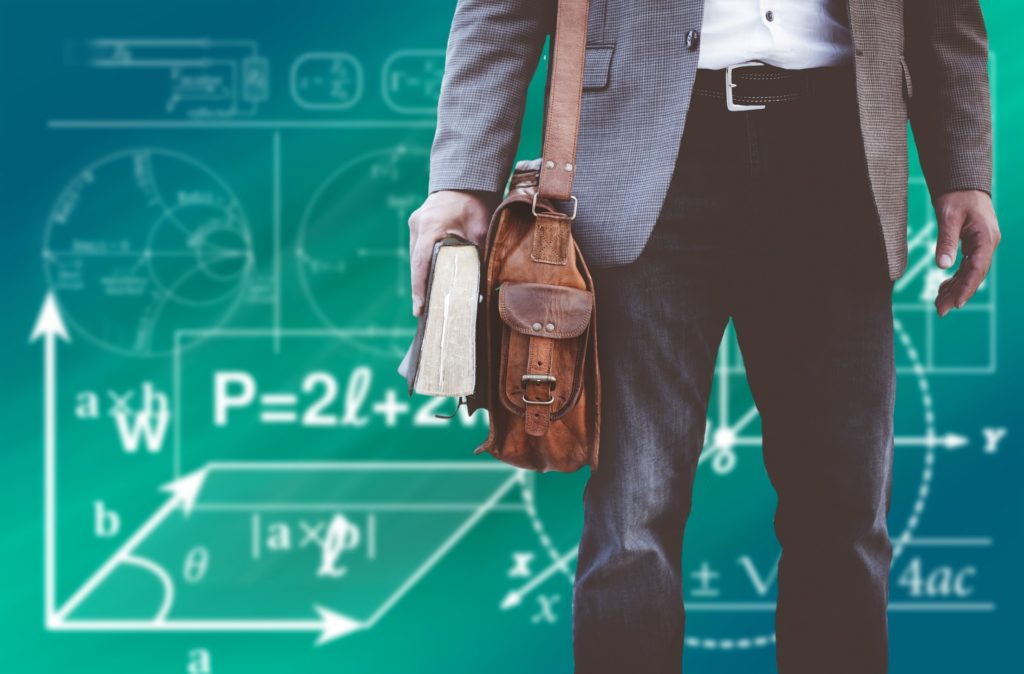 Man in front of board with equations on