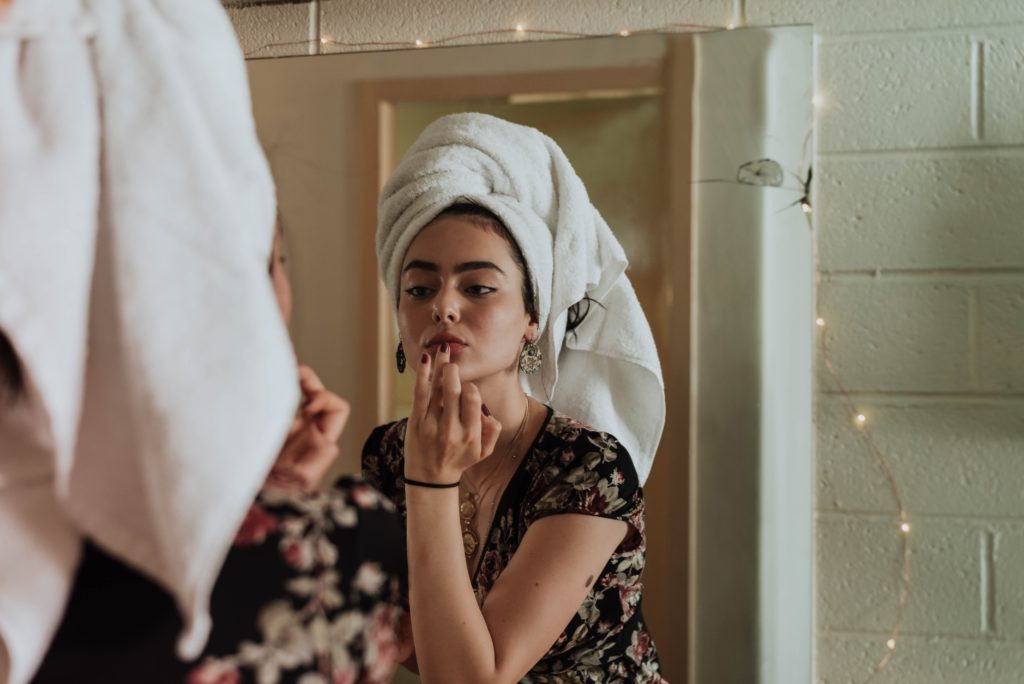 Woman looking in mirror at her lips