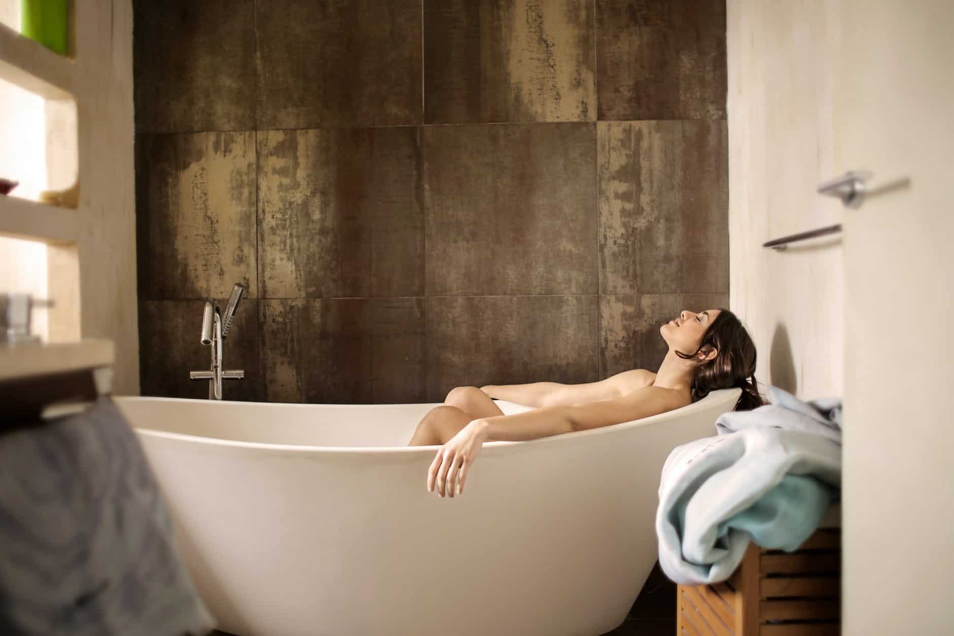 woman lying on bathtub filled with water