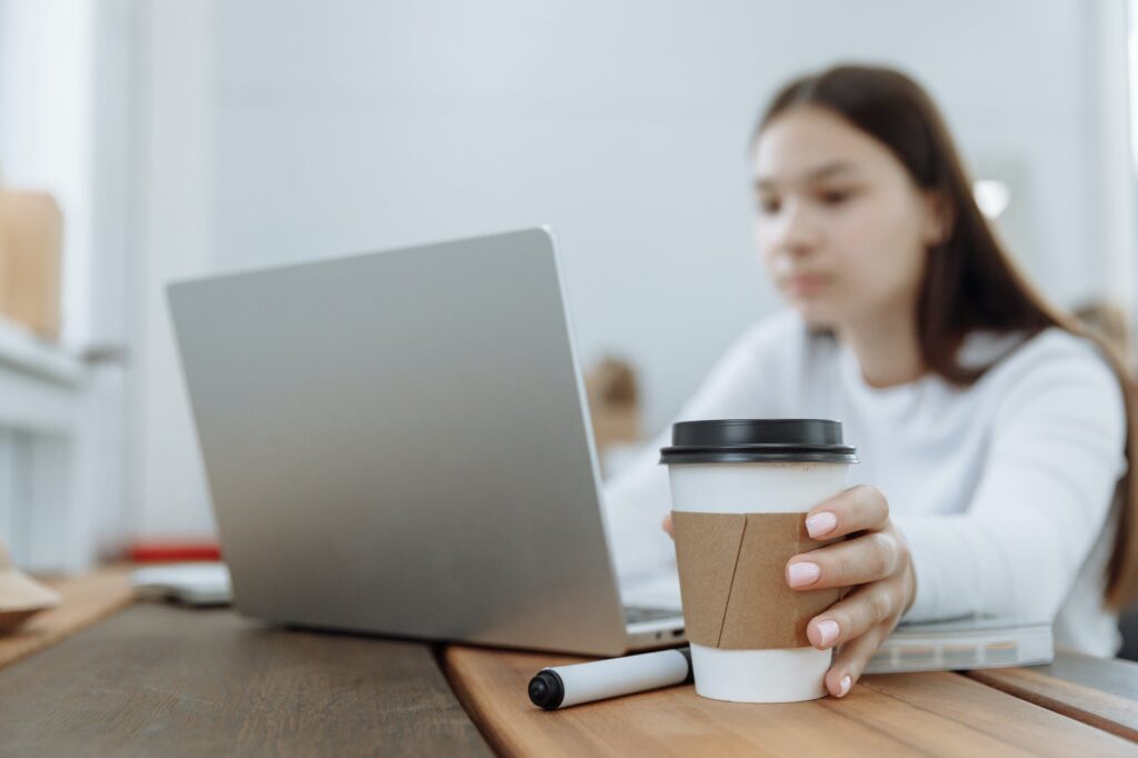 woman working on her laptop on a wooden table